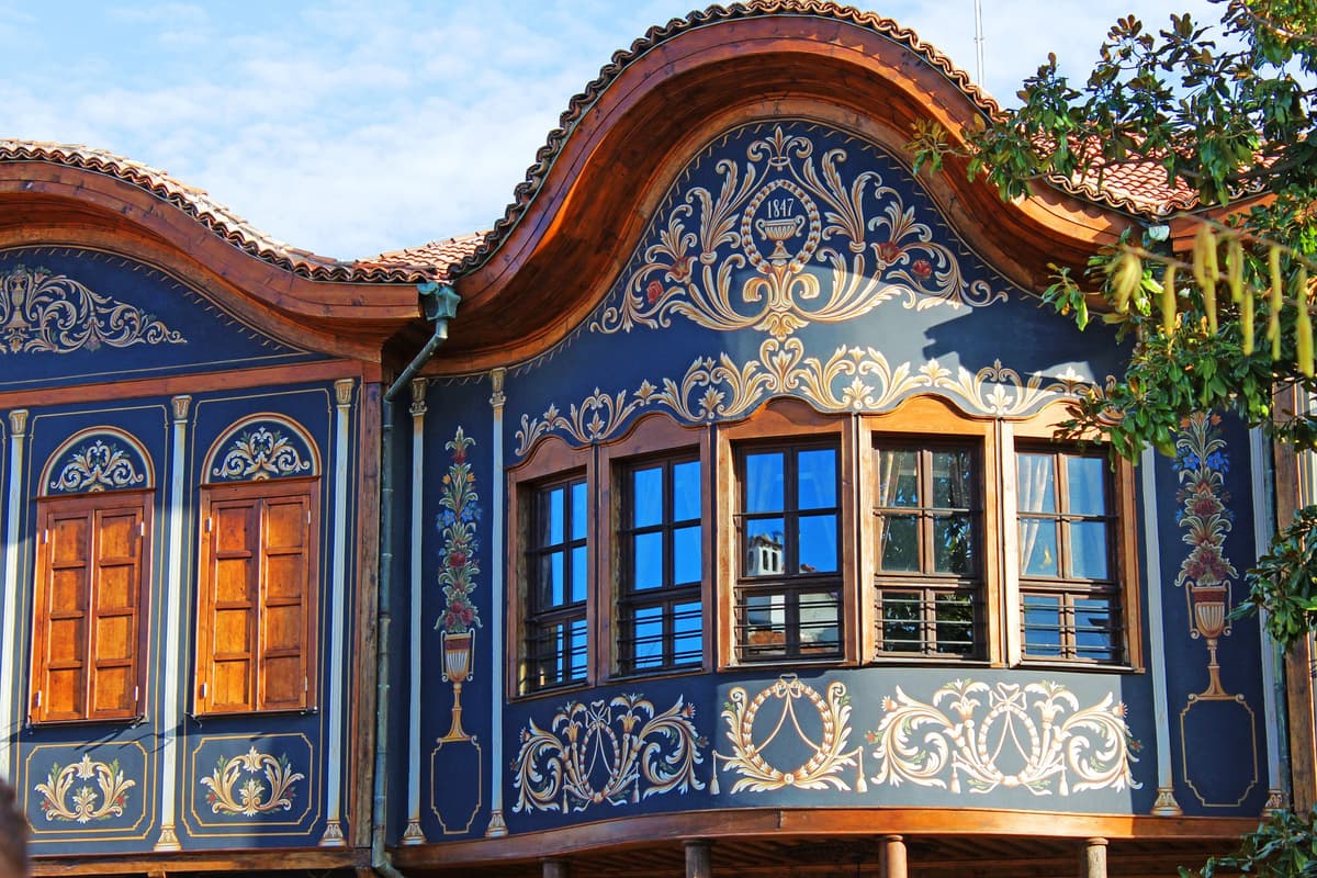 Painted Bulgarian National Revival house in Plovdiv from 1847, blue facade with golden floral ornaments in Bulgarian National style, wooden windows and curved tile roof